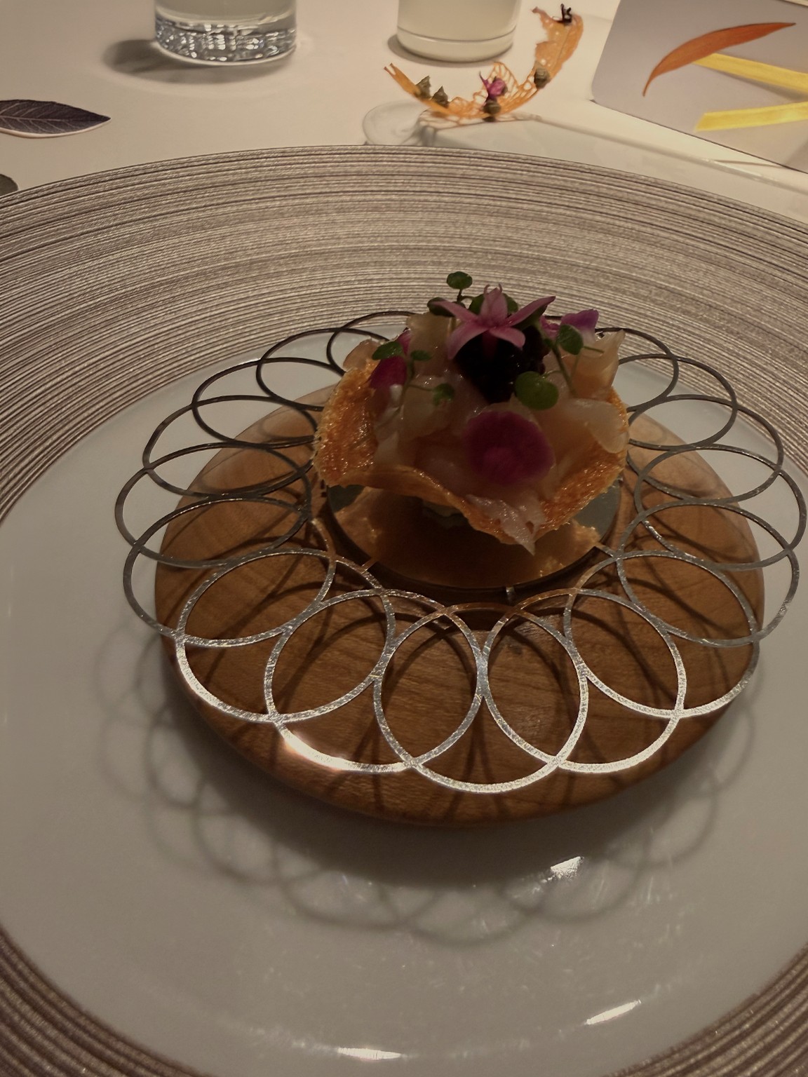 A raw-fish tartlet in a dark restaurant, as shot on a phone